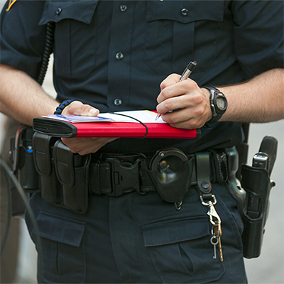 Armed officer making notes.